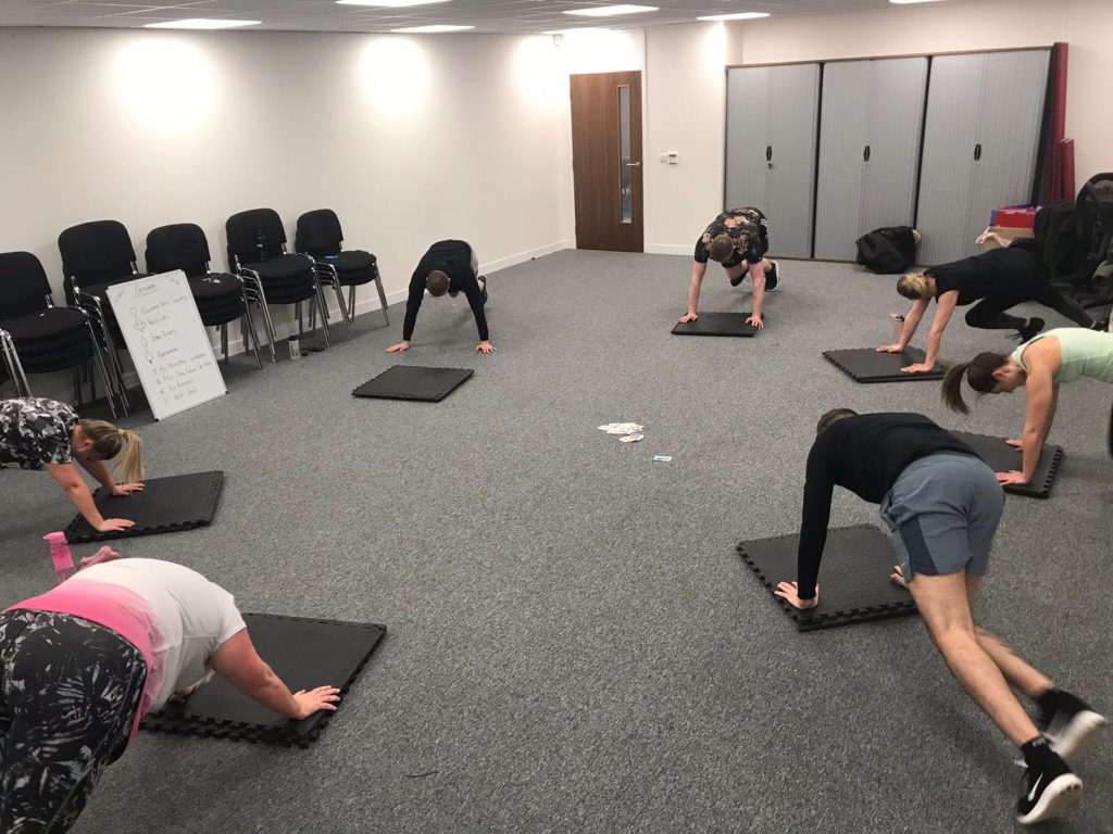 group of people doing push ups on exercise mats