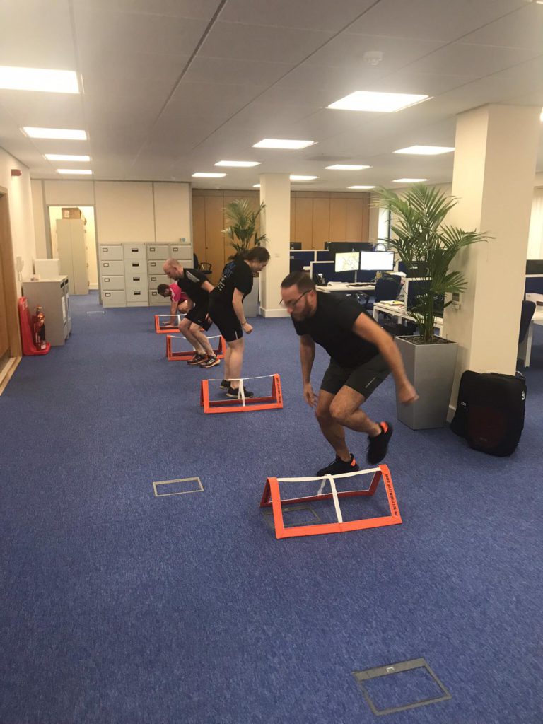 four people completing a mobile fitness course in an office
