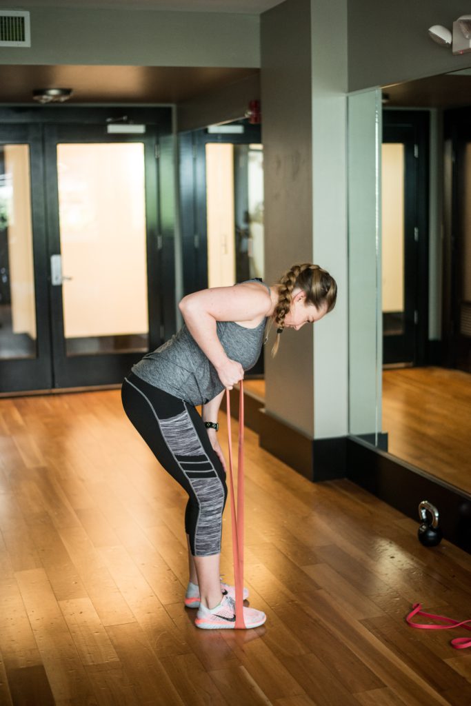 Woman using resistance band in front of mirror