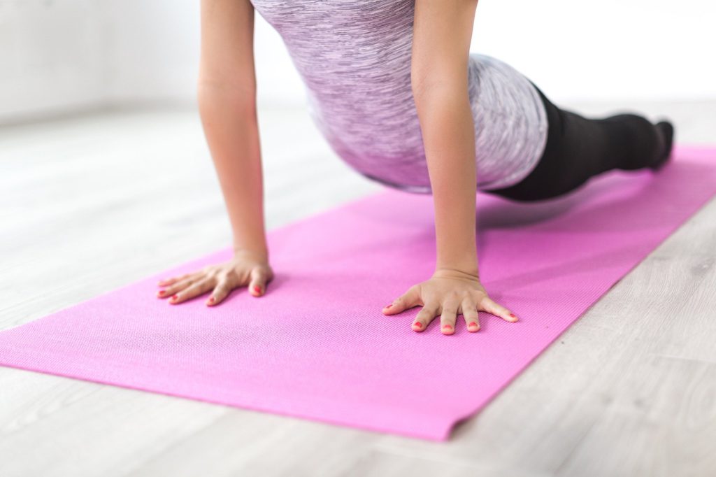 Girl using exercise mat for a home workout.